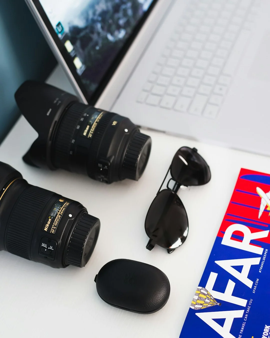 Camera lenses and laptop on a minimal workspace